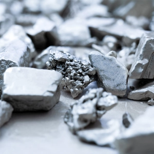 Chunks of metallic rocks lie scattered, reflecting light in a blurred, abstract setting.